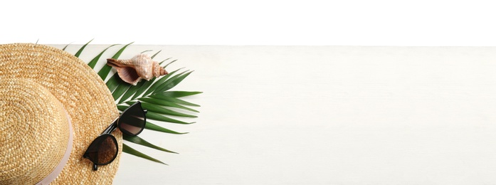 Photo of Hat, sunglasses, sea shell and leaf on white wooden table, space for text. Beach accessories