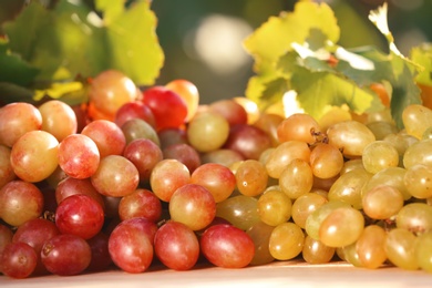 Photo of Fresh ripe juicy grapes on table against blurred background