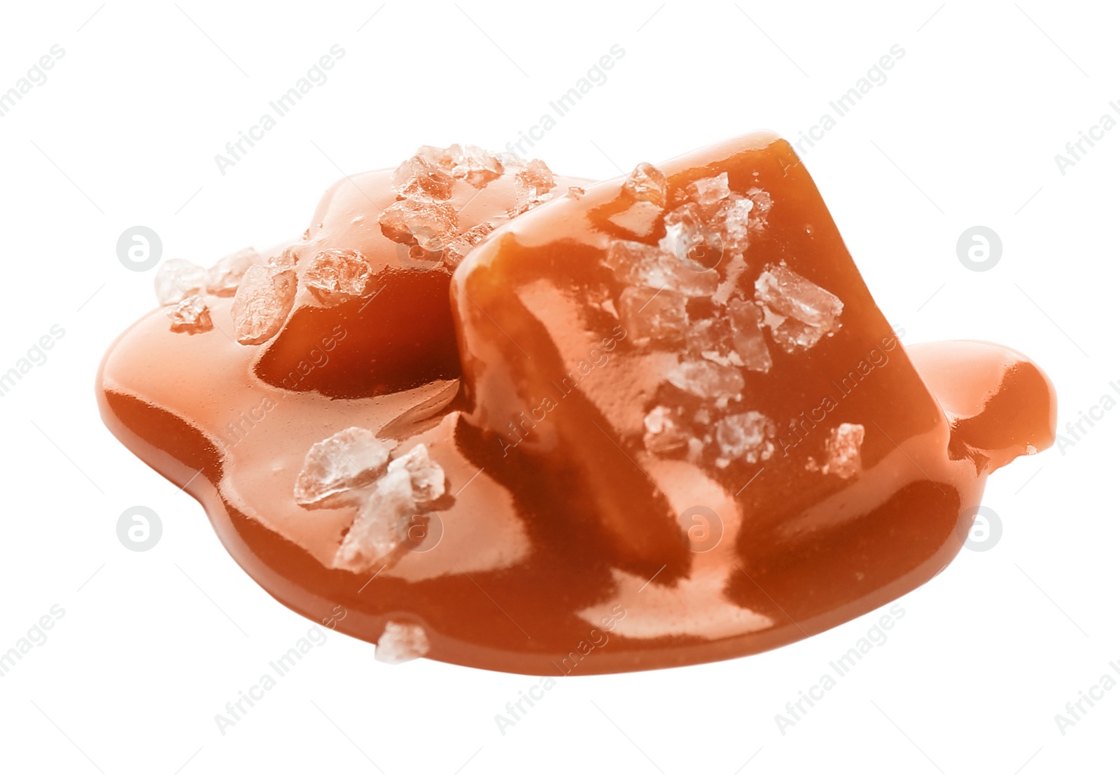 Photo of Caramel candies under tasty sauce with salt isolated on white