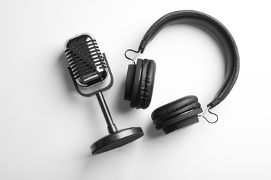 Retro microphone and headphones on white background, top view