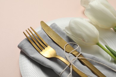 Photo of Stylish table setting with cutlery and tulips on pink background, closeup
