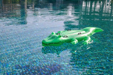Photo of Float in shape of crocodile in swimming pool outdoors