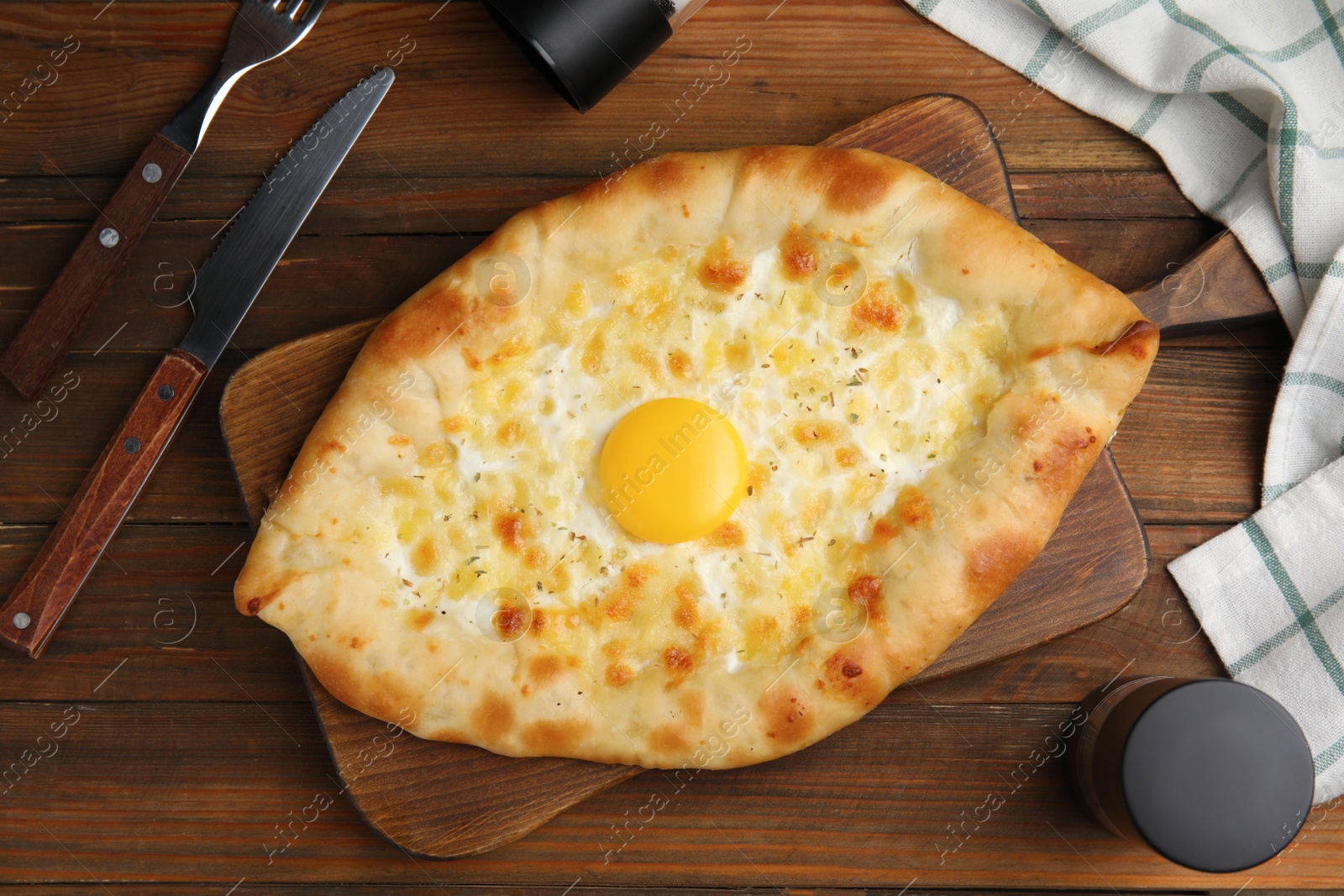Photo of Fresh homemade khachapuri with cheese and egg served on wooden table, flat lay