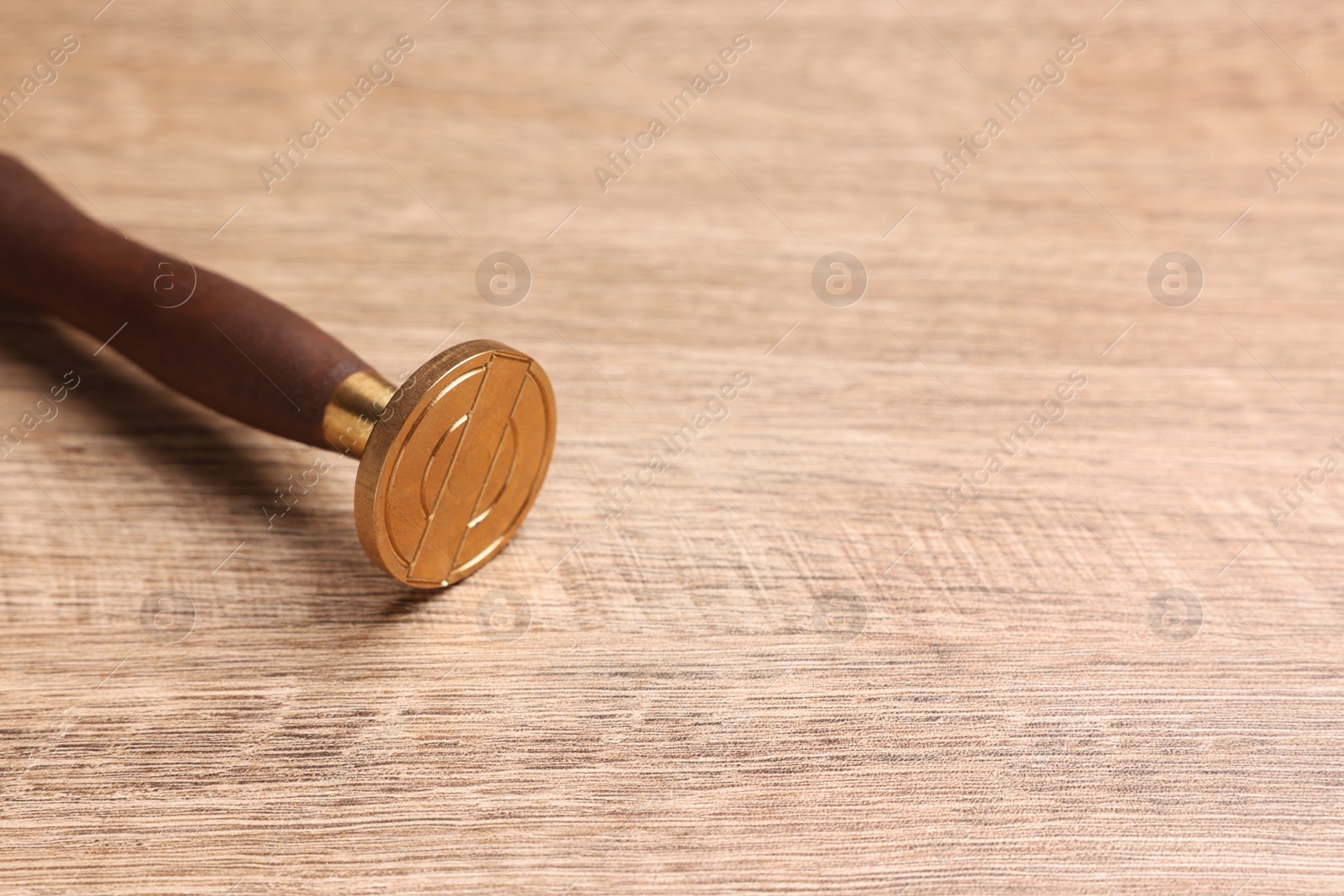 Photo of One stamp tool on wooden table, closeup. Space for text