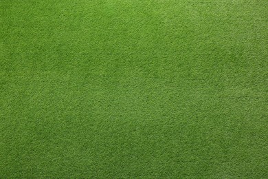 Green artificial grass as background, top view