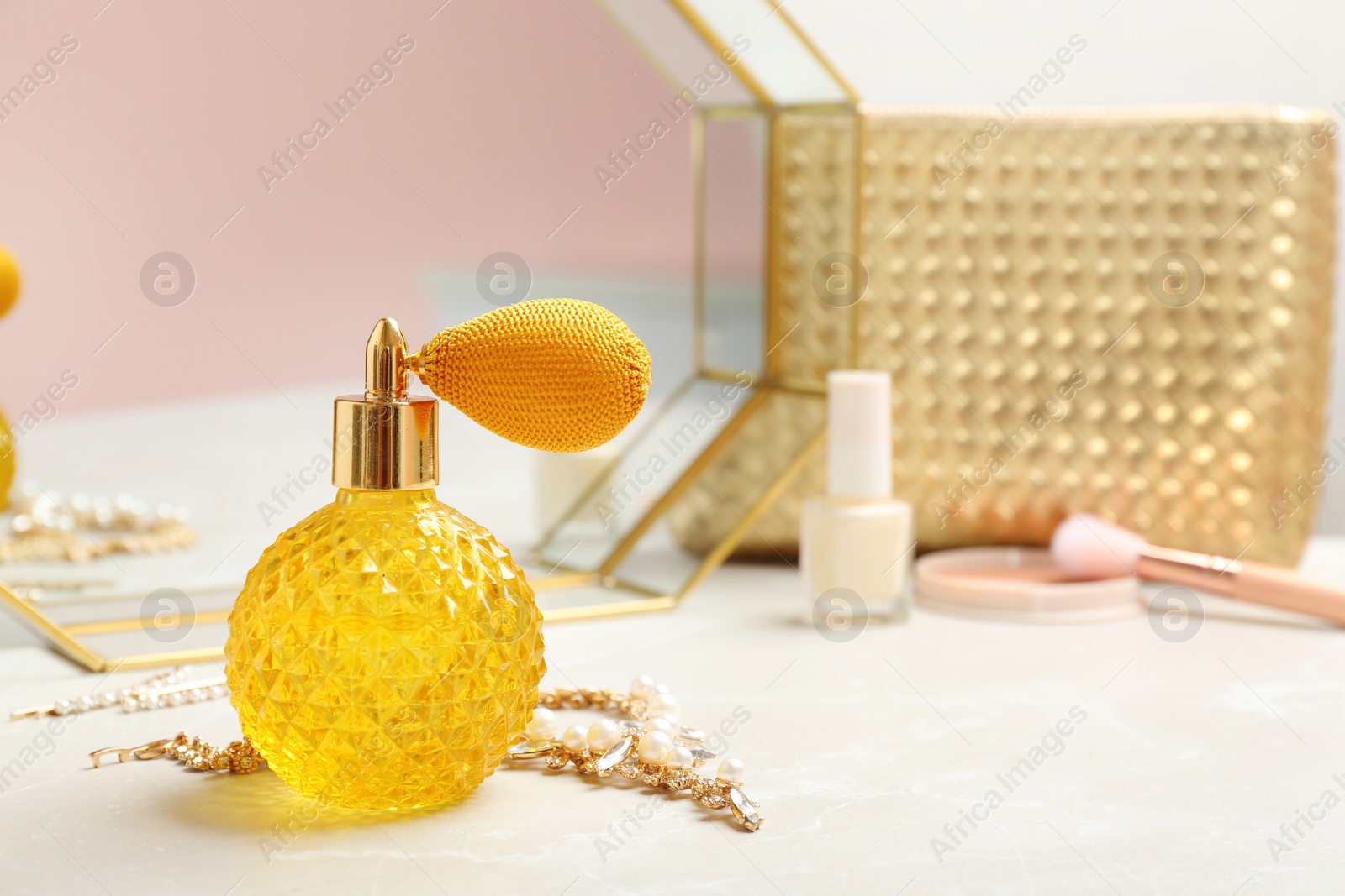 Photo of Vintage crystal bottle of luxurious perfume and jewelry on dressing table, space for text