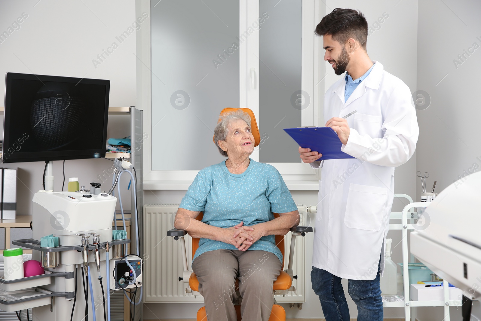 Photo of Senior woman visiting otolaryngologist in clinic. Hearing aid