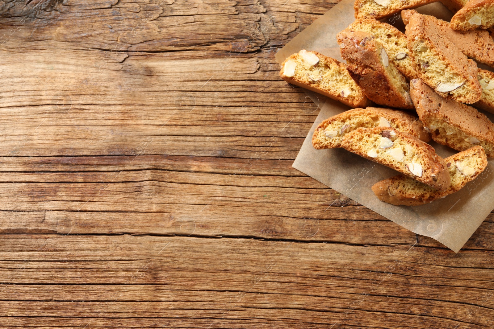 Photo of Traditional Italian almond biscuits (Cantucci) on wooden table, flat lay. Space for text