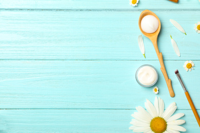 Photo of Flat lay composition with chamomiles and cosmetic products on light blue wooden background. Space for text