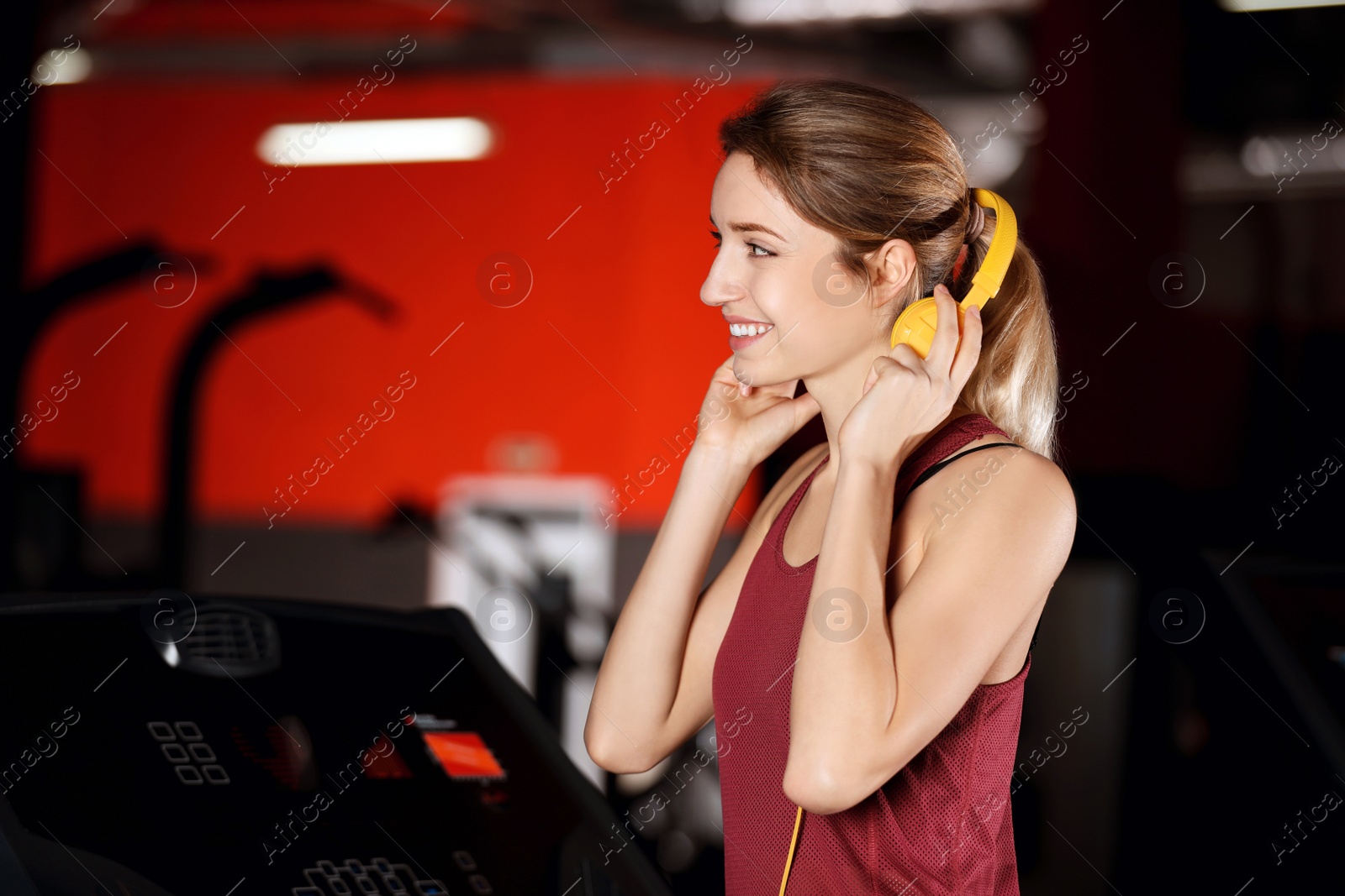 Photo of Beautiful young woman with headphones at gym