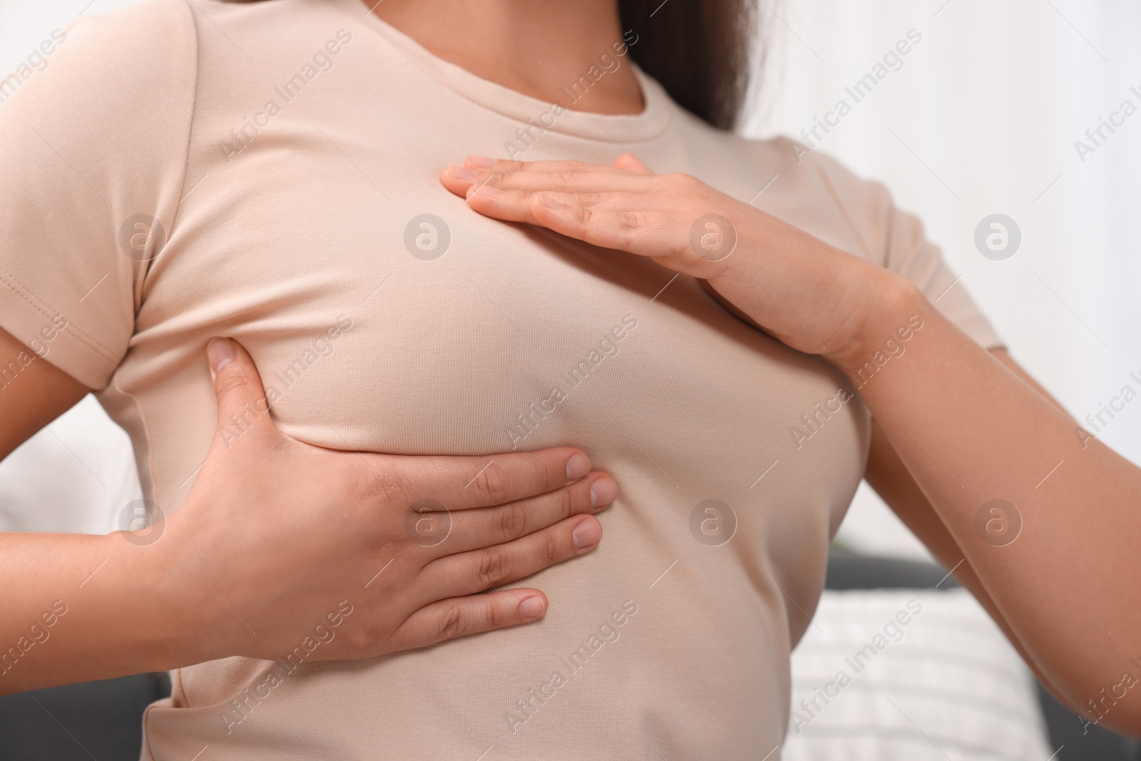 Photo of Woman doing breast self-examination at home, closeup