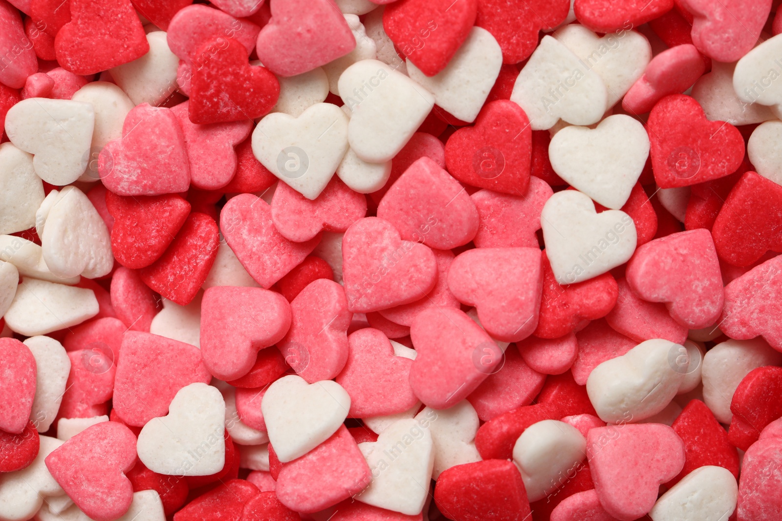 Photo of Sweet candy hearts as background, top view