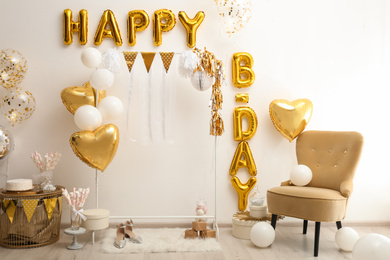 Phrase HAPPY BIRTHDAY made of golden balloon letters in decorated room