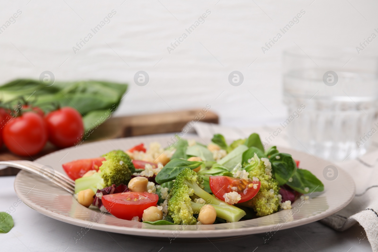 Photo of Healthy meal. Tasty salad with quinoa, chickpeas and vegetables on table, closeup