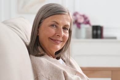 Portrait of beautiful senior woman on sofa at home