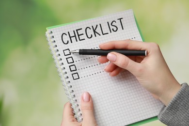 Woman filling Checklist against blurred background, closeup