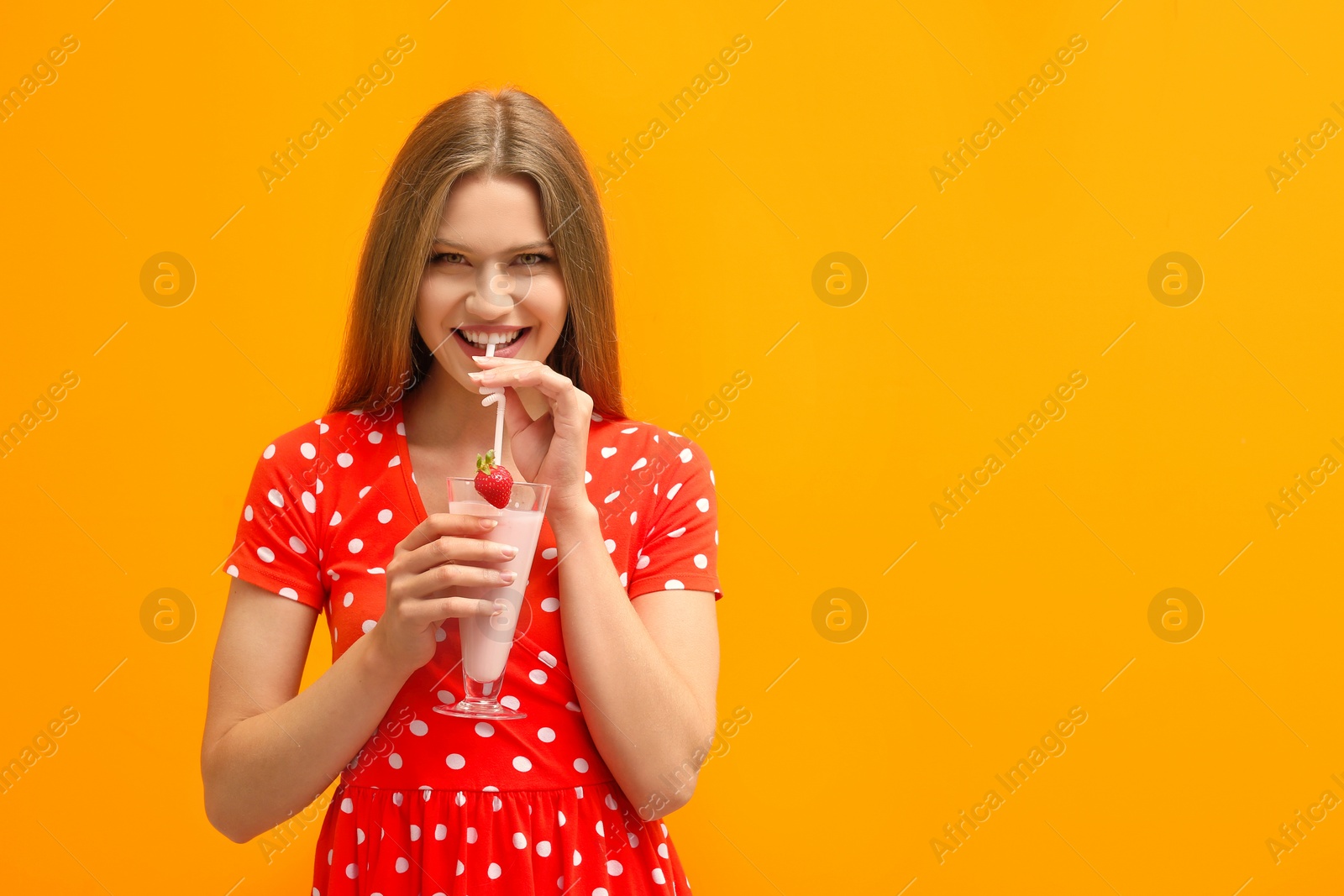 Photo of Young woman with glass of delicious milk shake on color background