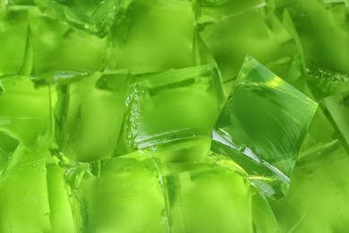 Photo of Green jelly cubes as background, closeup view