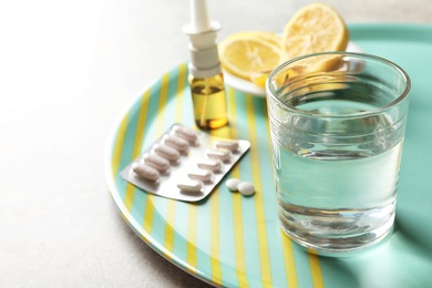 Photo of Glass with water and different cold remedies on tray