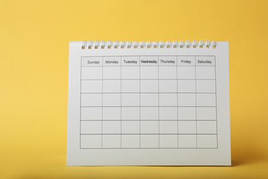 Photo of Blank paper calendar on yellow background. Planning concept