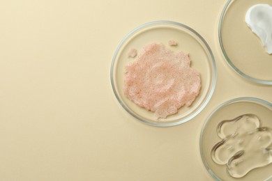 Photo of Many Petri dishes and cosmetic products on beige background, flat lay. Space for text