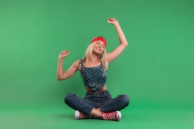 Portrait of happy hippie woman on green background