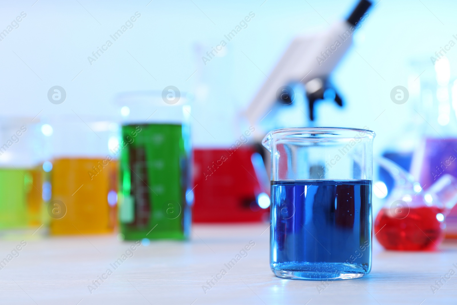 Photo of Beaker with sample on table in chemistry laboratory, space for text