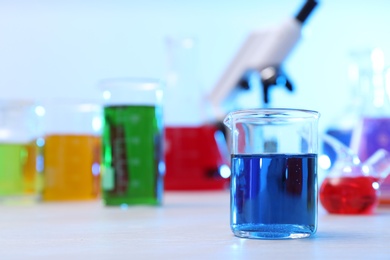 Beaker with sample on table in chemistry laboratory, space for text