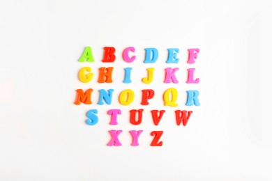 Photo of Colorful magnetic letters on white background, flat lay. Alphabetical order