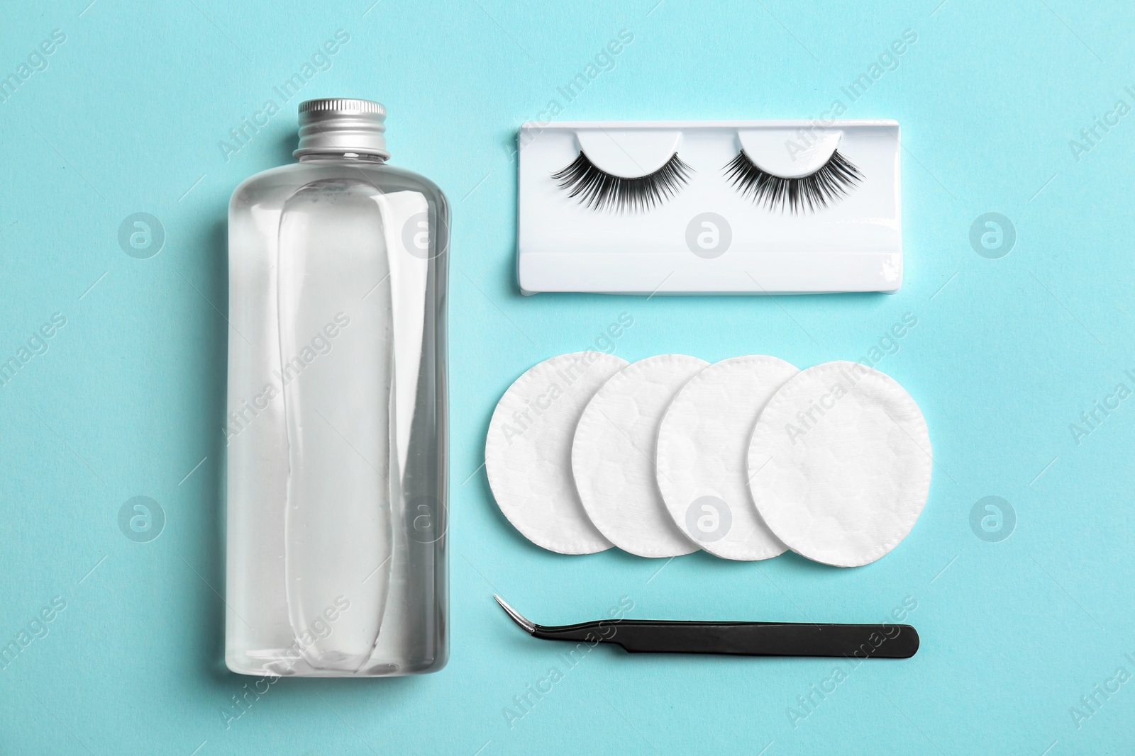 Photo of Flat lay composition with false eyelashes, lotion and tweezers on color background