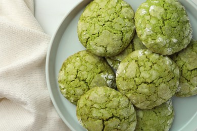 Plate with tasty matcha cookies on white table, top view