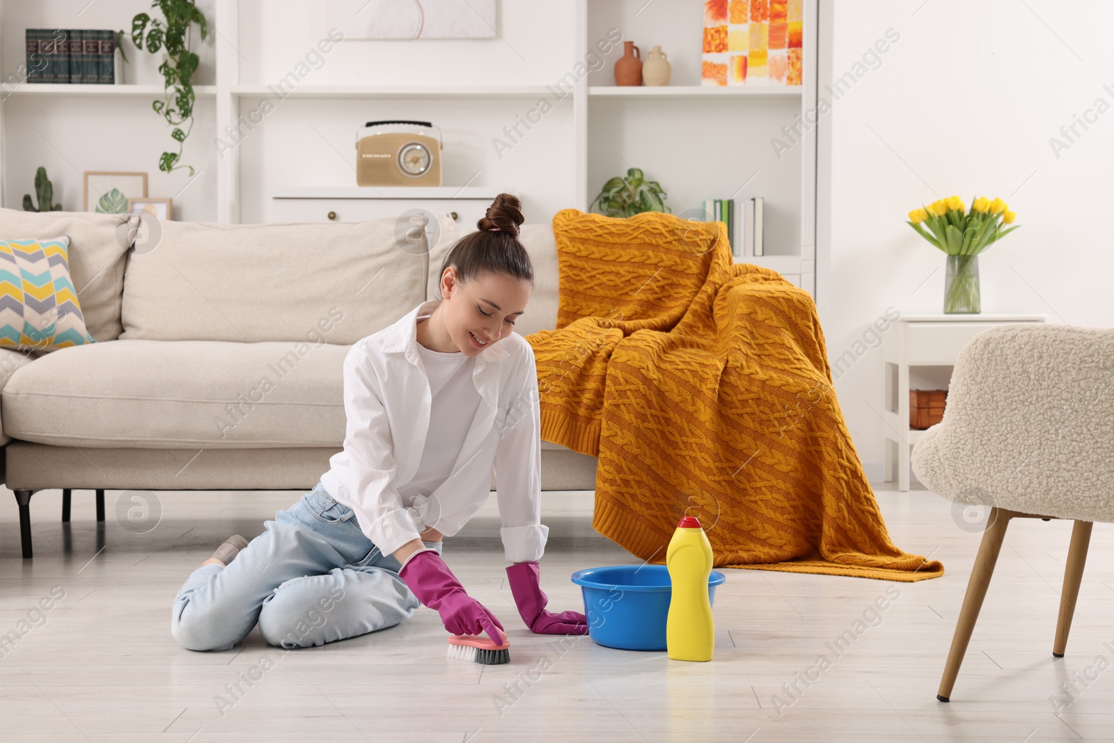 Photo of Spring cleaning. Young woman tidying up living room at home