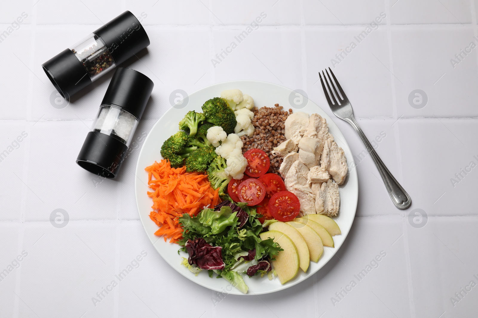 Photo of Balanced diet and healthy foods. Plate with different delicious products served on white tiled table, top view