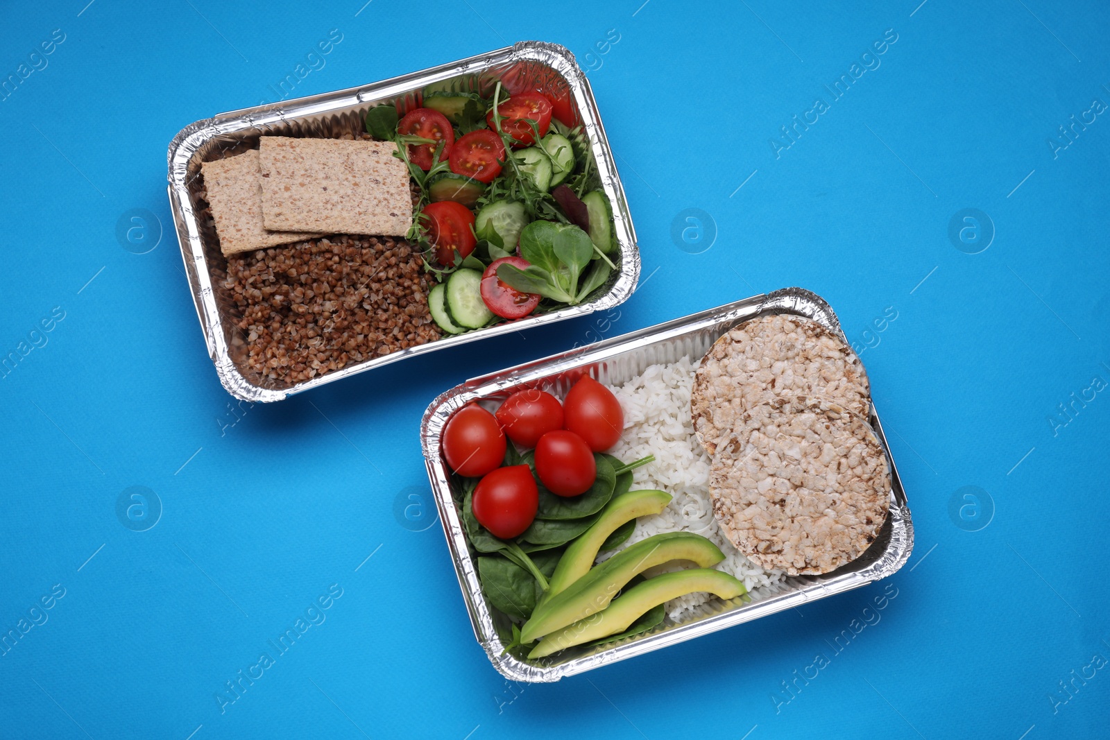 Photo of Containers with different fresh products on light blue background, flat lay