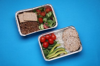 Containers with different fresh products on light blue background, flat lay