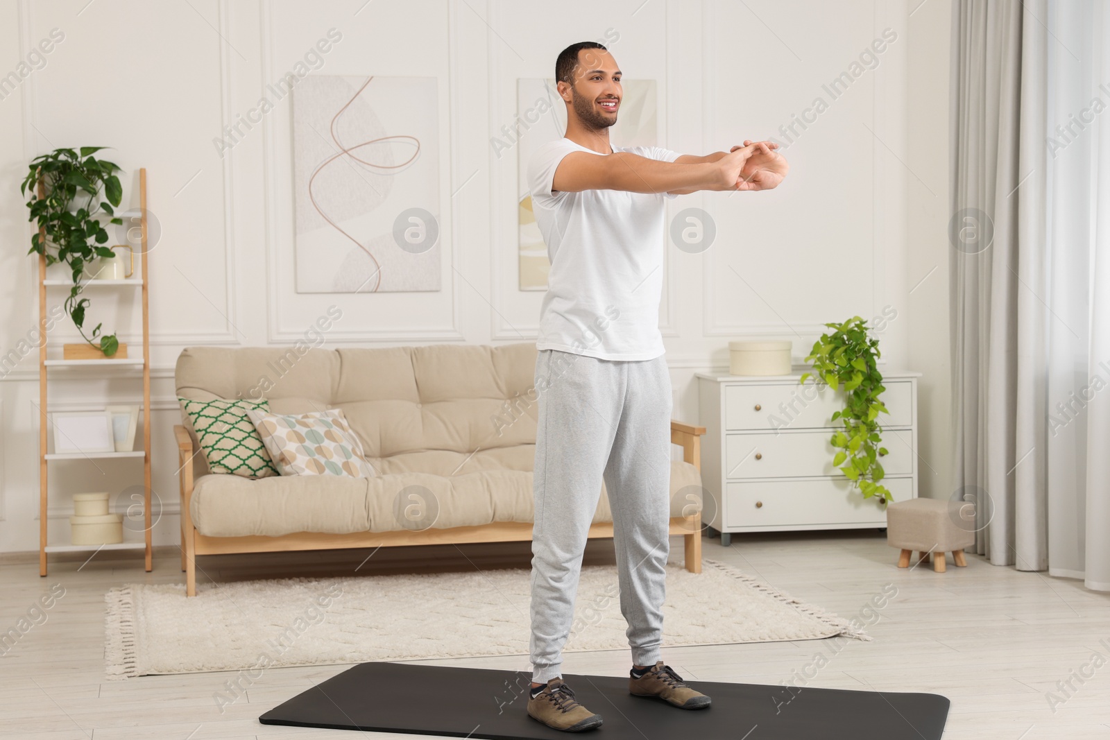 Photo of Man doing morning exercise on fitness mat at home