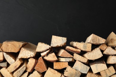 Photo of Cut firewood on black background. Heating in winter