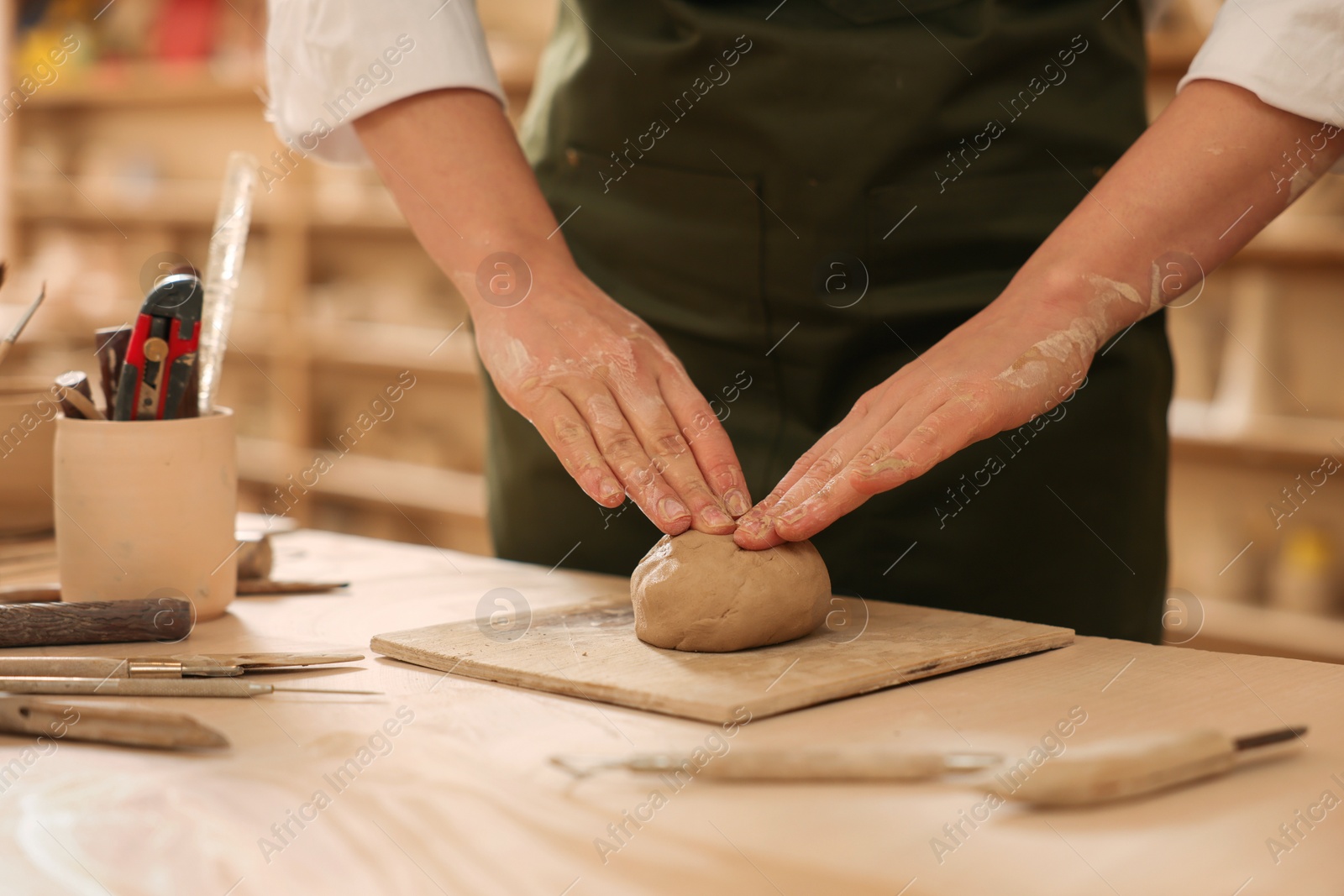 Photo of Woman crafting with clay at table indoors, closeup