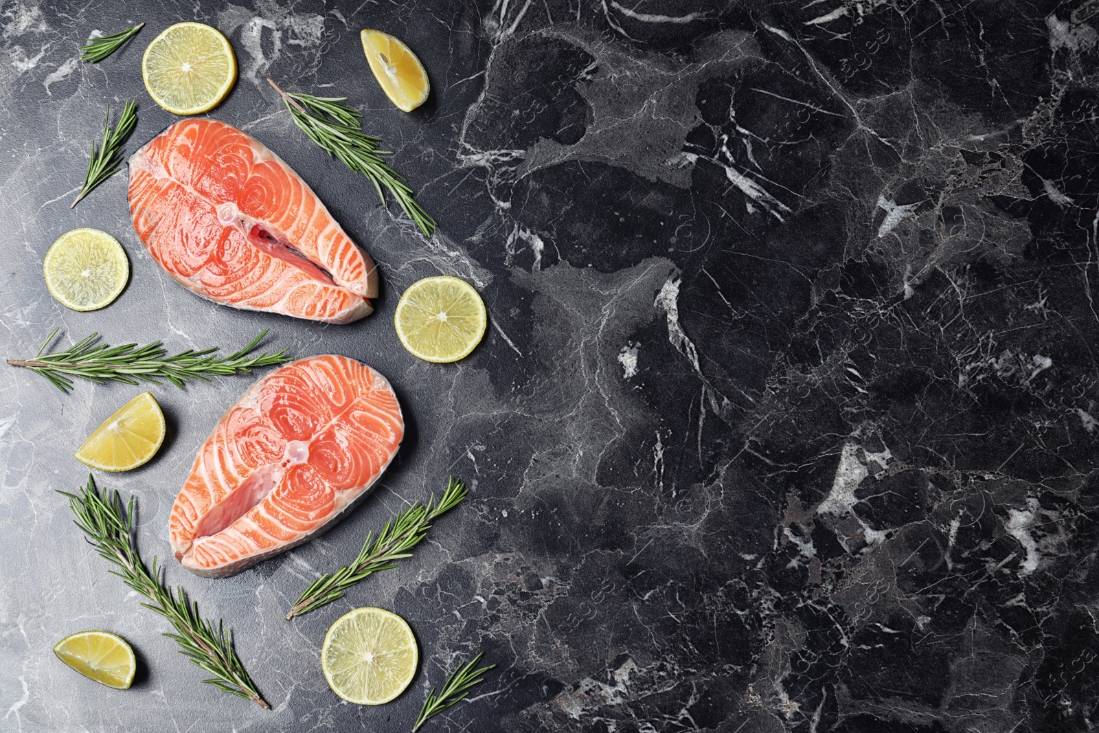 Photo of Flat lay composition with fresh raw salmon and rosemary on black marble table, space for text. Fish delicacy