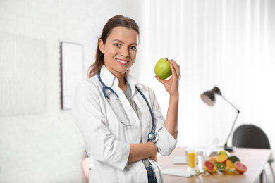 Photo of Nutritionist with fresh apple in her office