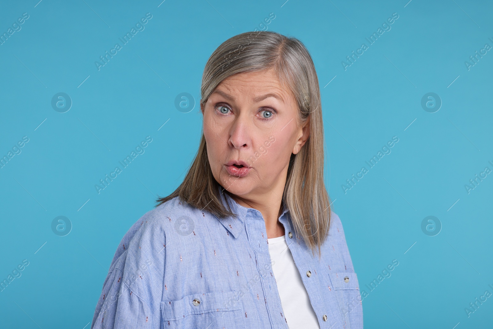 Photo of Portrait of surprised senior woman on light blue background