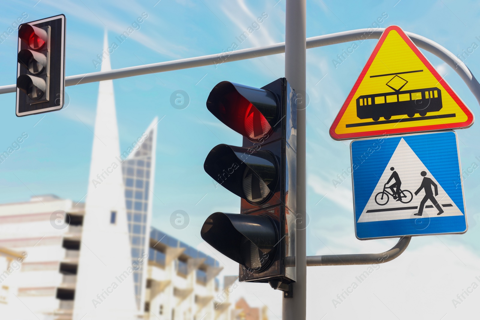 Photo of Post with Tram and Pedestrian crossing road signs near traffic lights outdoors