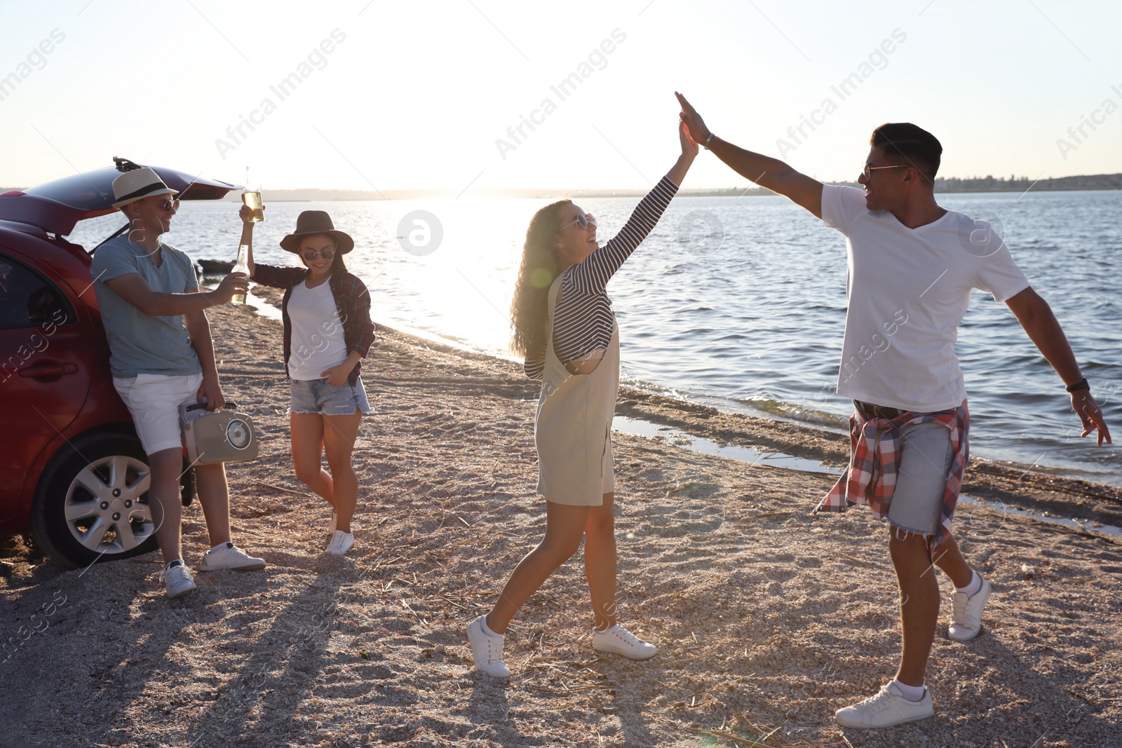 Photo of Happy friends having fun near car on beach. Summer trip