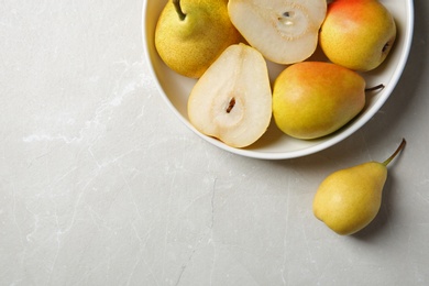 Photo of Plate with pears on grey background, top view. Space for text