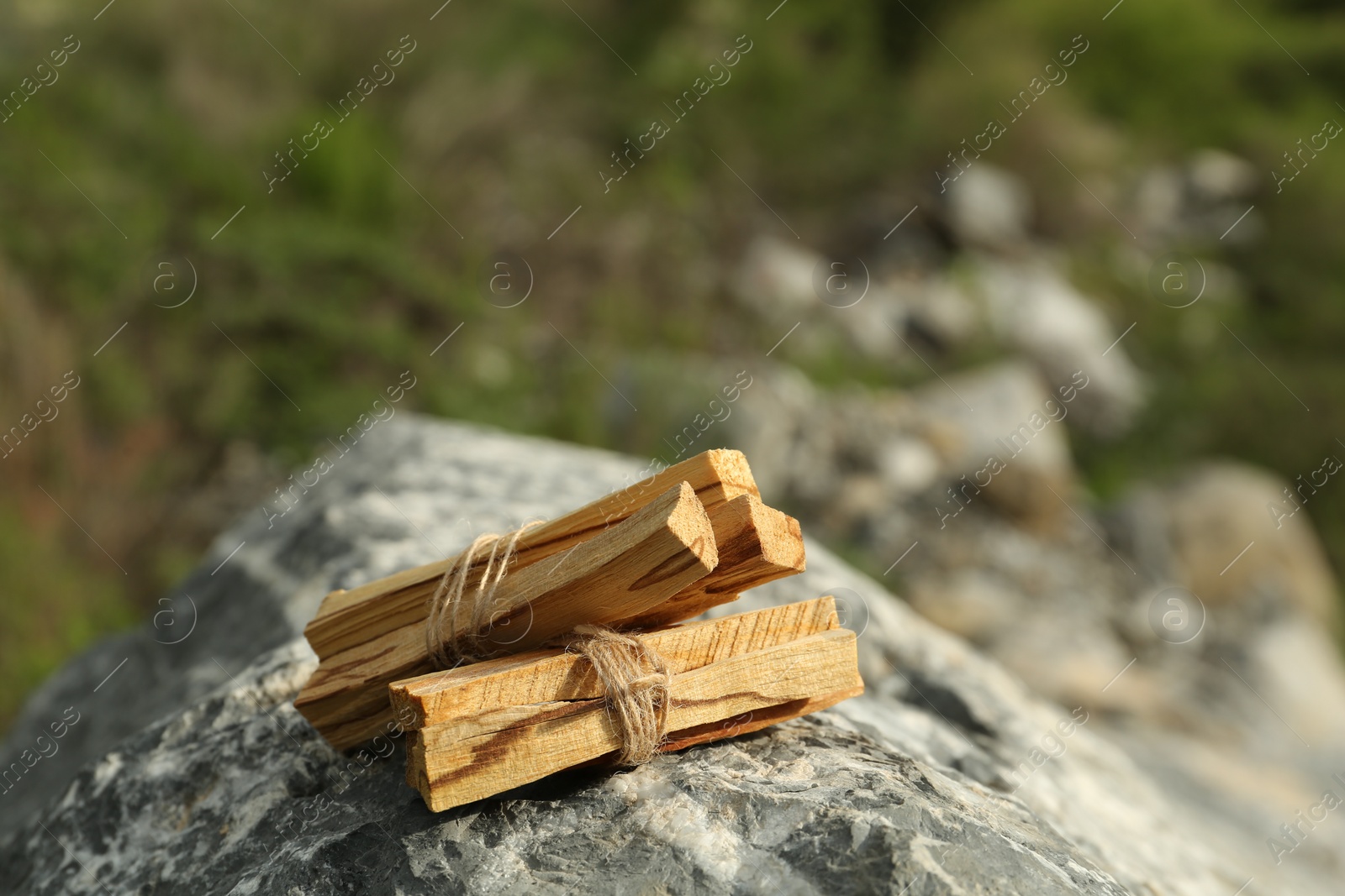 Photo of Many palo santo sticks on stone surface outdoors