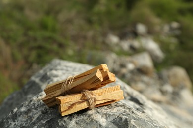 Many palo santo sticks on stone surface outdoors