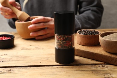 Photo of Ground pepper and grains on wooden table, selective focus. Space for text