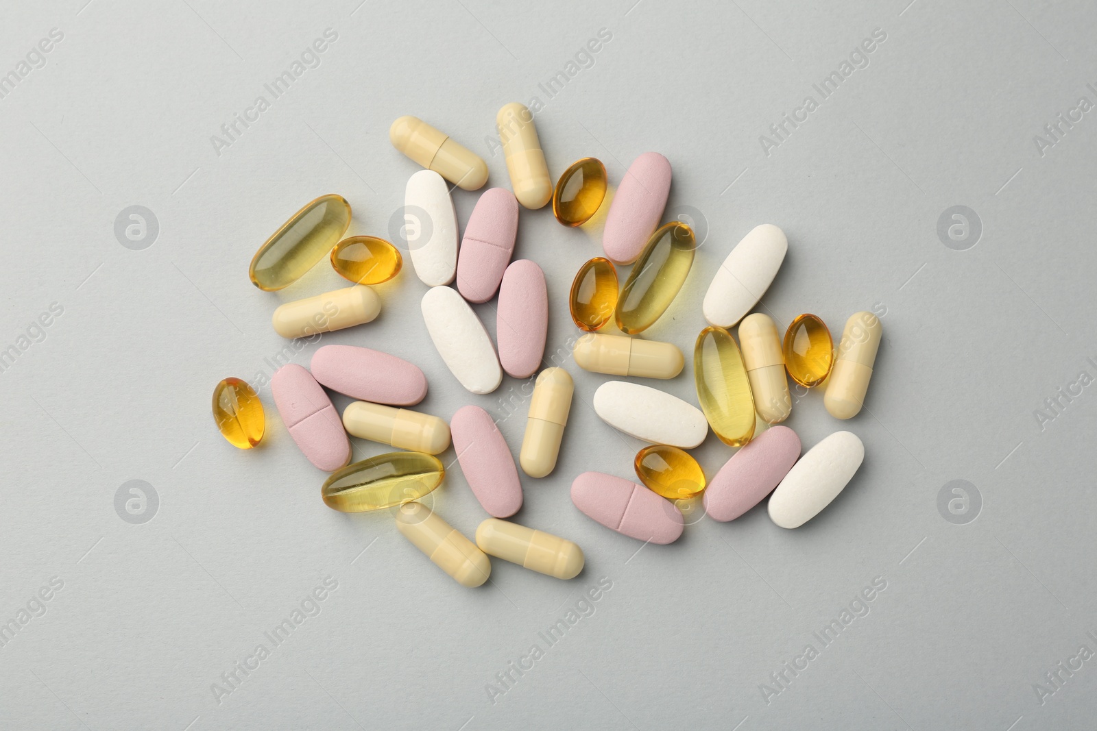 Photo of Different vitamin pills on light grey background, top view. Health supplement