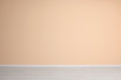 Empty room with beige wall and wooden floor