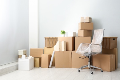 Photo of Cardboard boxes and packed chair indoors. Moving day